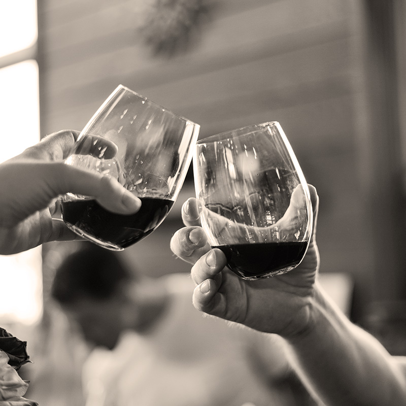 Two people toasting with glasses of red wine